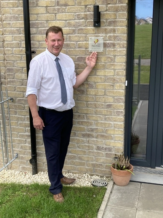 Chris Wilson, Contracts Manager with the Passivhaus plaques.